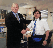 a man in a suit and tie shakes hands with a man in a white shirt and blue tie