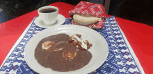 a plate of food and a cup of coffee on a table cloth