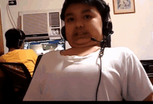 a boy wearing headphones and a microphone is looking at the camera