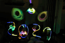 a group of people holding glow in the dark sticks that spell out the year 2020