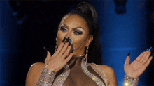 a drag queen with long black nails is covering her mouth with her hand