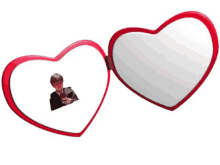 a heart shaped mirror has a picture of a man in a suit in it