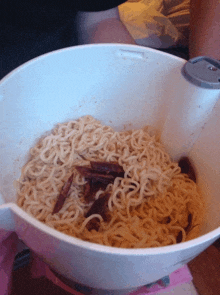 a white bowl filled with noodles and bacon