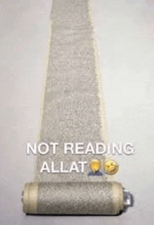 a roll of toilet paper with the words `` not reading allat '' written on it is on a table .