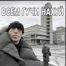 a man and a woman are standing in front of a building with the words " всем гучи нахуй " written on it