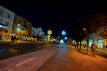 a blurry picture of a city street at night with a sign that says ' farmacia ' on it