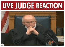 a man in a judge 's robe sits in front of a sign that says live judge reaction