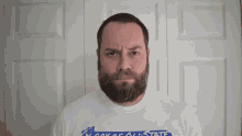 a man with a beard is wearing a white shirt that says alaska state