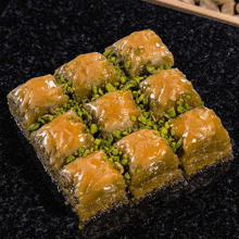 a tray of baklava with pistachios on top