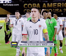 a group of soccer players are standing on a field and one of them is wearing a white jersey with the number 10 on it .