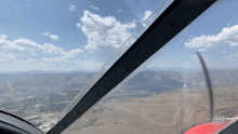 a plane is flying over a desert with mountains in the distance