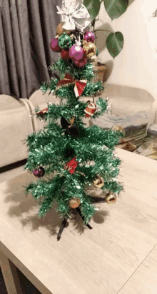 a small christmas tree on a table with decorations