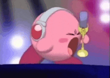 kirby is wearing headphones and holding a microphone while singing into it .