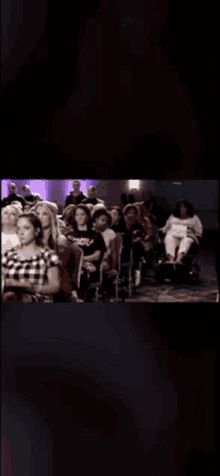 a group of people are sitting in chairs at a conference .