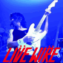 a man is playing a guitar in front of a blue background that says livewire