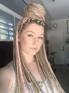 a woman with blonde braids and pink extensions takes a selfie