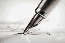 a fountain pen is writing on a piece of paper with a signature