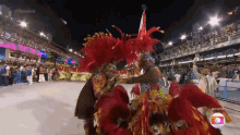 a group of people in colorful costumes are dancing in front of a crowd and the word globo is on the bottom of the screen