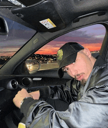 a man in a black hat is sitting in a car