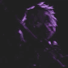 a man with purple hair is holding a gun in a dark room .