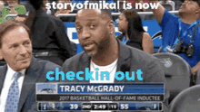 tracy mcgrady is sitting in the stands watching a basketball game