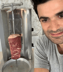 a man is smiling in front of a kebab machine that says ' gyro ' on it