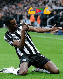 a soccer player is kneeling on the field with a flag behind him