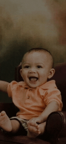 a baby is sitting in a chair and smiling