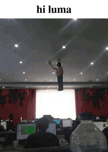 a man is flying through the air while holding a remote control in an office with the words hi luma above him