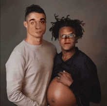 a man and a pregnant woman are posing for a photo