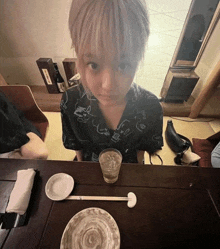 a person sitting at a table with a cup of water