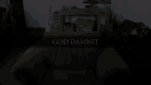 a dark room with a chair and the words god damnit in red letters