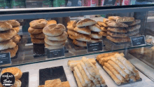 a display case filled with a variety of breads and pastries with the words knead to bake on the bottom