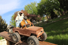 two monkeys are riding in a rusted toy jeep