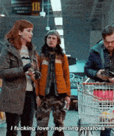 a group of people are standing in a grocery store talking to each other while a man pushes a shopping cart .