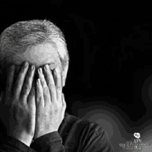 a black and white photo of a man covering his face with his hands with the words afu in the corner