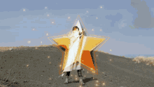 a woman in a white coat stands in front of a large star