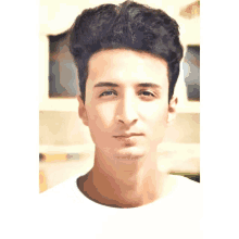 a close up of a young man 's face with a white shirt on