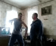 two men are dancing in a living room in a blurry photo .