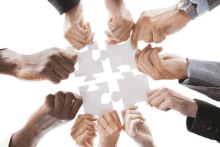 a group of people holding puzzle pieces in their hands