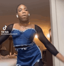 a man wearing a blue dress and black sleeves is dancing on tiktok