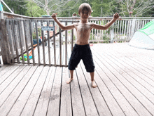 a young boy flexes his muscles on a deck with a sign behind him that says ' where the power is '