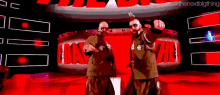 two men in military uniforms are dancing in front of a large red sign that says the next big thing