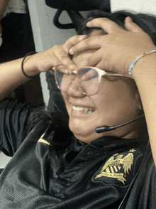 a woman wearing glasses and a black shirt that says " united to defeat "