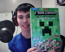 a man wearing headphones holds a box of minecraft cereal