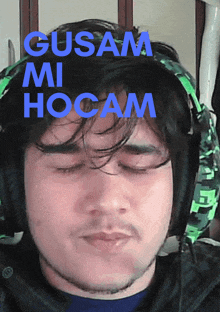 a man wearing headphones with the words gusam mi hocam on top of his head