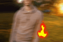 a blurry picture of a person with a red and yellow fire coming out of their arm