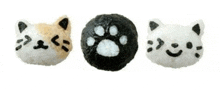 three balls of rice in the shape of a cat 's face and paw print .