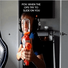 a boy wearing headphones is holding a nerf gun in front of a tv screen