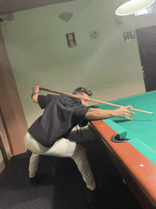 a man is playing pool with a cue stick